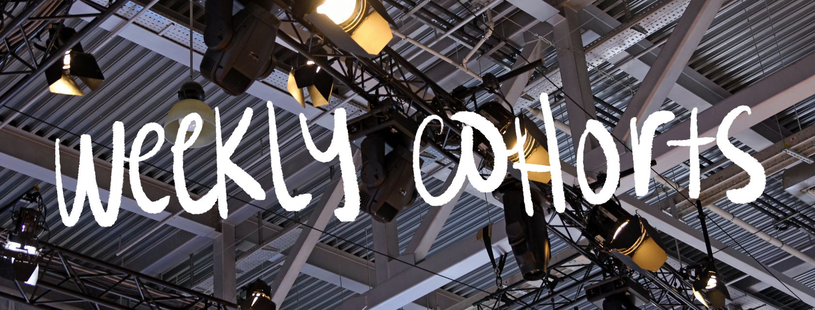 Stage lights with an overlay of text: weekly cohorts