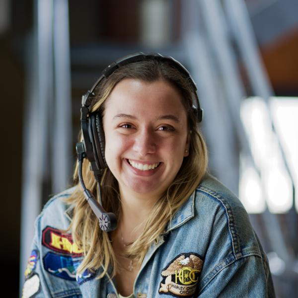 white woman with a stage crew headset smiling at the camera